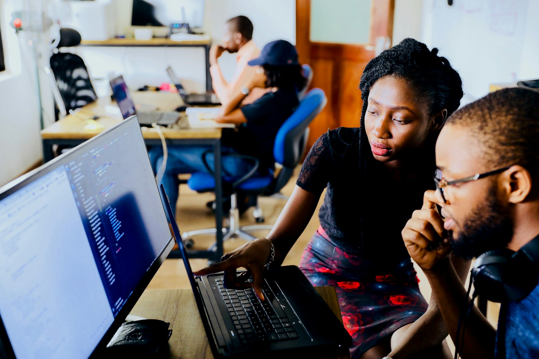 Young African professionals learning together at computers
